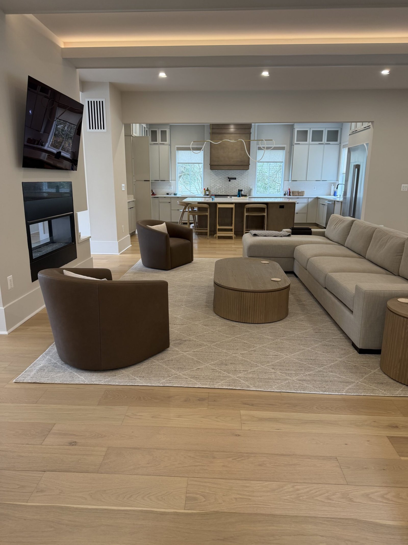 Tysons modern open-plan great room with sectional sofa and leather chairs