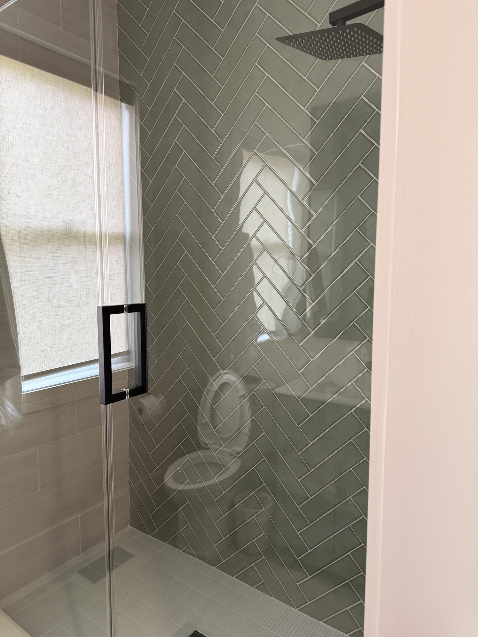 Luxury bathroom with sage green herringbone shower tile