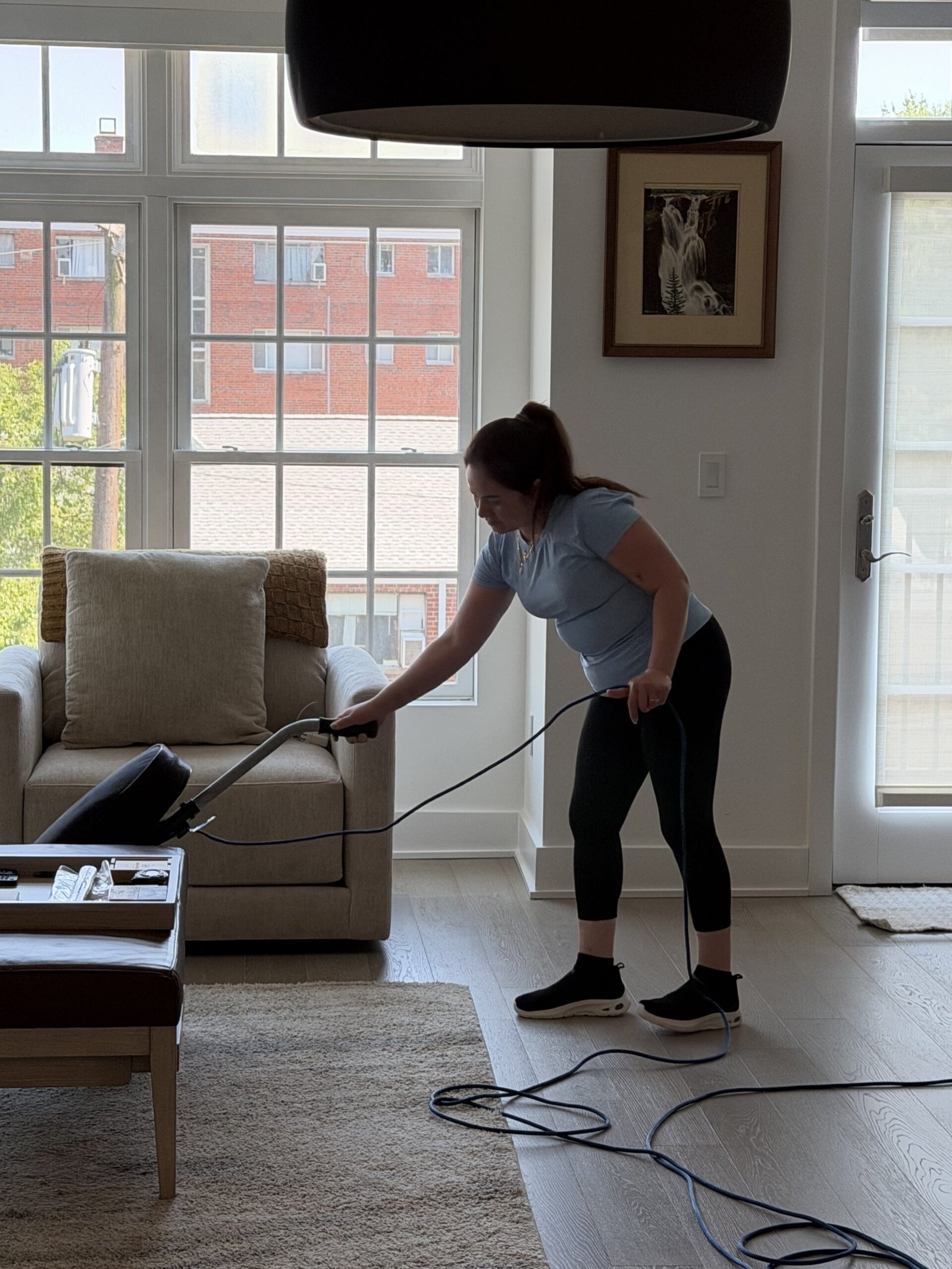 Vicky's Cleaning Service crew member vacuuming Arlington home
