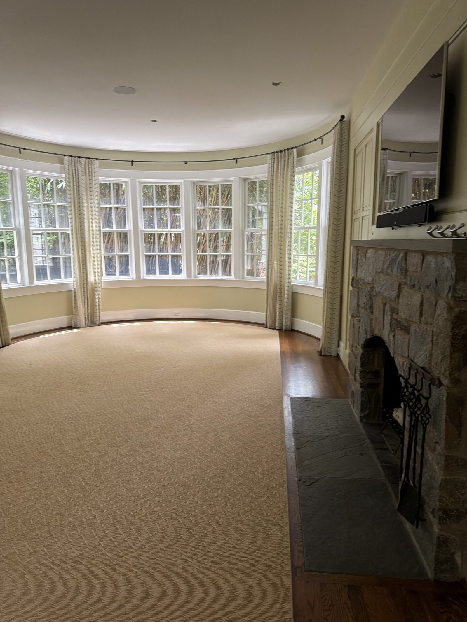 McLean curved living room with stone fireplace and bay windows